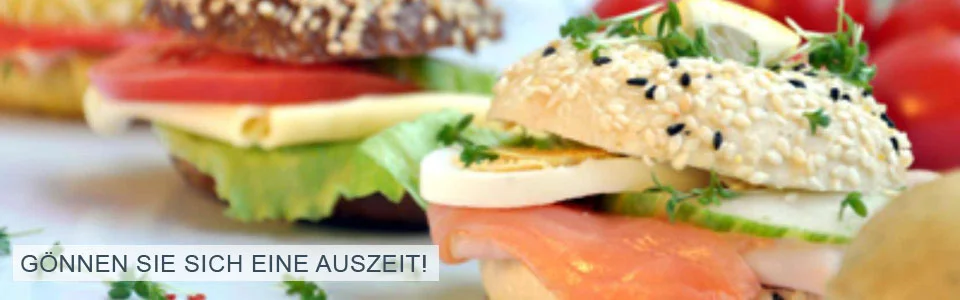 Bild eines Sesam-Bagels mit Lachs und Ei mit dem Slogan: Gönnen Sie sich eine Auszeit!